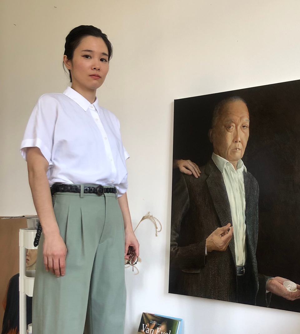 haruka-maeda Mann mit Brille und lockigen Haaren vor rotweisser Jalousie